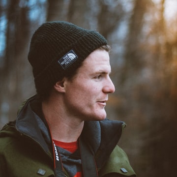 Stock portrait of a person wearing a dark hat outdoors