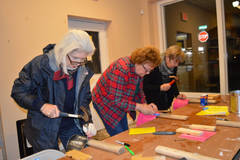 Two people working on craft projects at a table