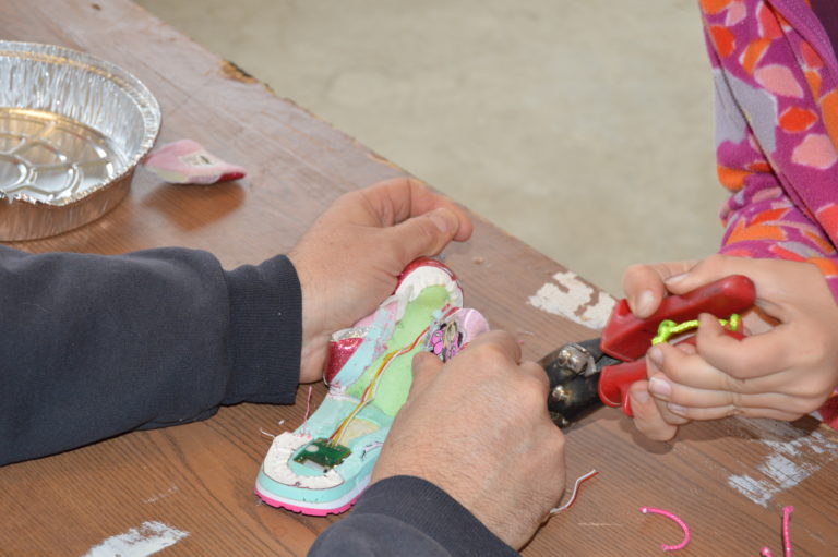 Hands working on a colorful fabric craft