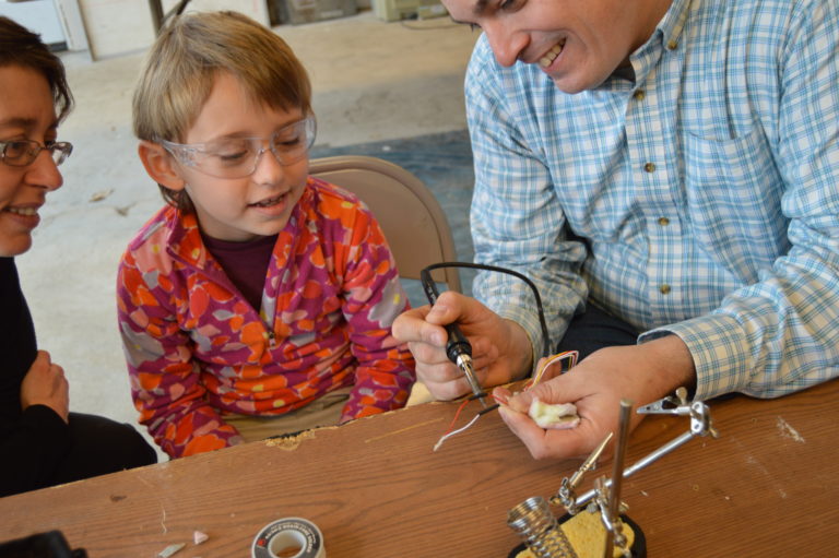 A child and adult working together on a small project