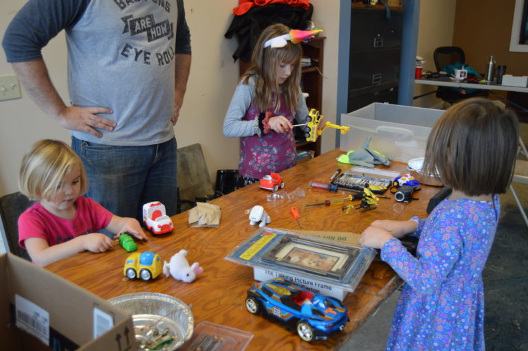 Children and adults making projects around a table